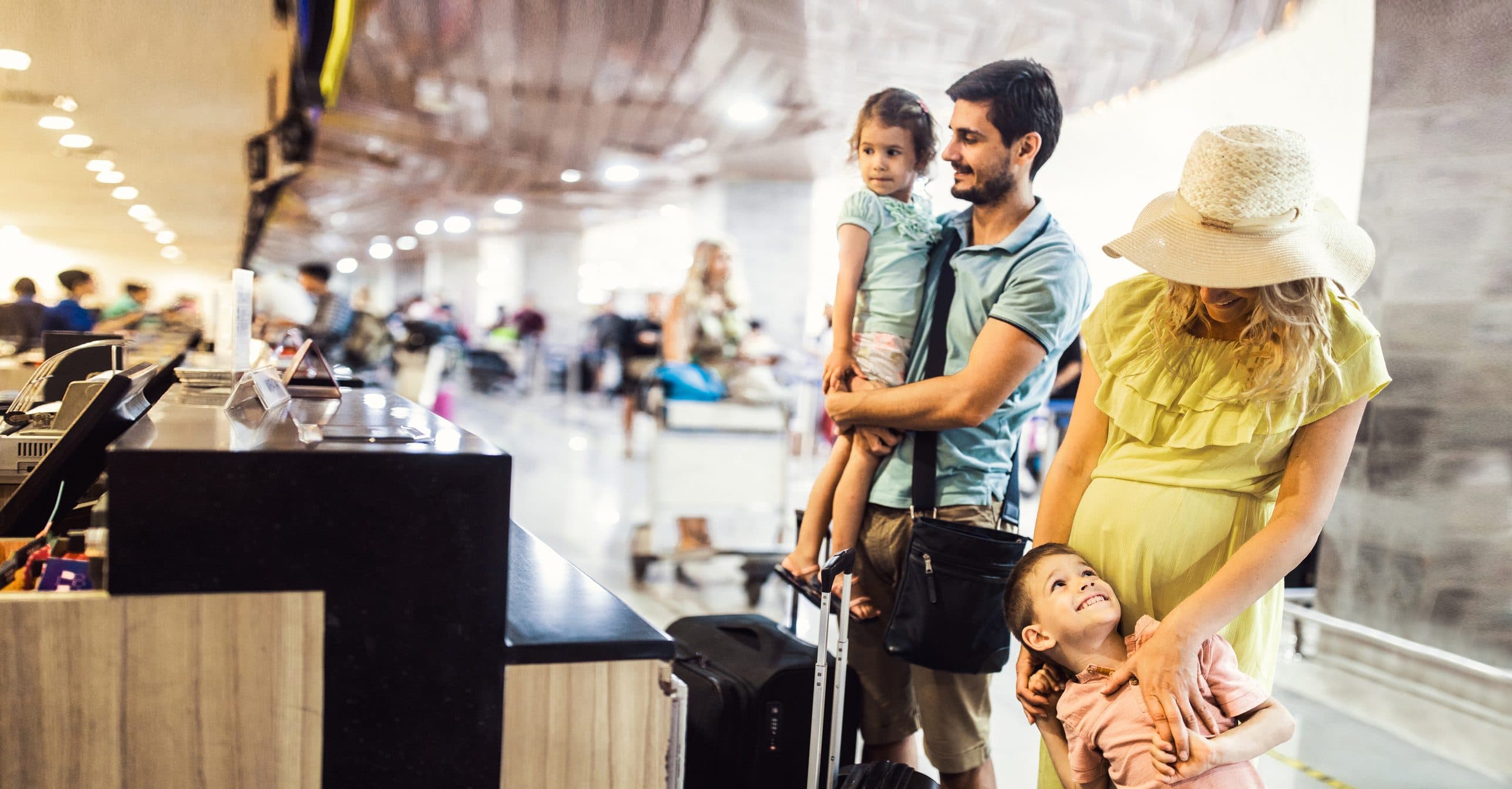 Young family checking their begs at airport terminal.